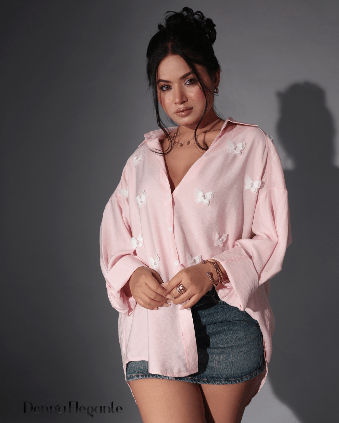 "Young girl wearing a light green summer dress with floral and butterfly prints, standing in a sunlit garden
