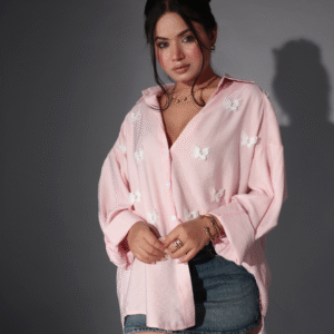 "Young girl wearing a light green summer dress with floral and butterfly prints, standing in a sunlit garden