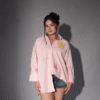 Model wearing an oversized embroidered pink shirt in pink with starfish beadwork – casual cotton outfit