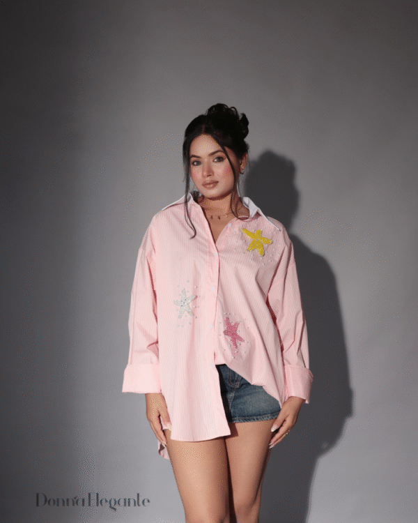 Model wearing an oversized embroidered pink shirt in pink with starfish beadwork – casual cotton outfit